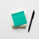 Stack of Post-it notes with pen — symbolizing collaboration and the find-a-colleague feature in hot desking